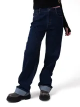 Pantalón de jean color azul oscuro con corte relajado, diseño de cinco bolsillos, cierre de cremallera y botón, y puños enrollados en la parte inferior de las piernas.