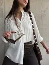 Camisa blanca de manga larga con detalles bordados en el canesú y cuello clásico.