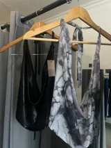 Top negro brillante con escote drapeado y espalda descubierta.