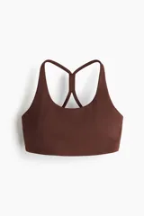 Top deportivo marrón de sujeción media con tejido SculptMove que moldea y DryMove que absorbe el sudor. Tiene escote redondo, espalda nadadora con tirantes cruzados y bajo elástico. Incluye copas con relleno extraíble.