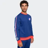 Buzo de cuello redondo color azul, con detalles en rojo y blanco en cuello, puños y ruedo. Presenta el escudo del Club Nacional de Football en el pecho y bandas laterales con diseño deportivo en las mangas.