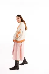 Buzo de tejido jacquard con diseño de formas orgánicas en tonos naranja y beige, de calce relajado, cuello alto y terminaciones tejidas en rib.