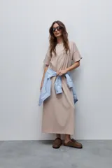 Vestido midi negro de algodón con calce relajado, silueta recta, cuello redondo, mangas cortas amplias y tajos laterales.