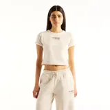 Remera crop top de color beige, con cuello redondo, manga corta y un delicado gráfico bordado en el centro del pecho.