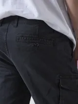 Bermuda de gabardina negra con bolsillos cargo laterales y corte recto.