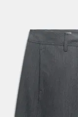 Pantalón de tiro medio color gris, con corte recto, bolsillos delanteros y detalle de costura vertical en el frente. Cuenta con cierre frontal de cremallera y botón.