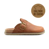 Zueco de cuero color suela con diseño de punta cerrada, ajuste mediante hebilla metálica lateral y base de corcho con suela dentada antideslizante.