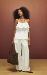 Blusa blanca de tirantes finos con volados en el escote y lateral, corte fluido.