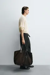 Polo de punto color crema con cuello solapa y abertura frontal, manga larga y diseño de trenzas.