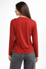 Remera de manga larga confeccionada en viscosa, con cuello en V y cierre frontal parcial con botones.