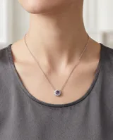 Collar de plata 925 con dije circular tipo flor, compuesto por una circonia central de color violeta rodeada por pequeñas circonias blancas brillantes.