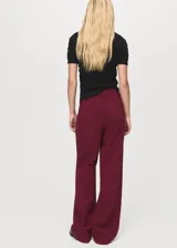 Pantalón de tiro medio color bordó, de diseño recto y largo, con trabillas para cinto y cierre oculto.