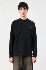 Remera negra de manga larga con cuello alto y logo bordado en el pecho.