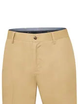Pantalón de gabardina de corte recto color beige con trabillas para cinto, bolsillos laterales y cierre frontal con botón y cremallera.