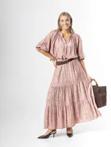 Falda larga de estilo campesino color rosado, con diseño amplio de volados y cintura elastizada. Incluye cinto color chocolate con hebilla dorada.