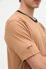 Remera blanca de algodón con textura suave, corte relaxed, manga corta, cuello redondo en contraste de color celeste y un bolsillo aplicado en el pecho.