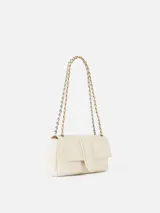 Cartera de cuero de cordero color blanco de silueta rectangular, con solapa frontal, cierre magnético y correa de cadena combinada con cuero trenzado. Incluye el logotipo de la marca grabado en dorado en el frente.