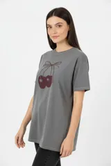 Remera de algodón color gris oscuro, con corte holgado, cuello redondo y estampado frontal de cerezas con lazo.