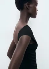 Top negro de diseño entallado con cuello barco, tirantes anchos y espalda abierta.