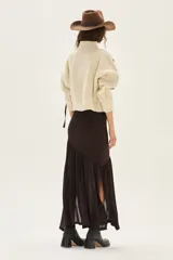 Polera de tejido de punto con diseño de ochos y detalles de tientos en contratono en las mangas. Presenta cuello alto y corte cropped.