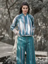 Pantalón de lino con estampado a rayas verticales en tonos celeste, verde, marrón y blanco.