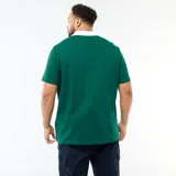 Remera estilo rugby de manga corta en color verde, con cuello polo blanco y cierre frontal parcial. Presenta un estampado tipográfico en el frente con la frase 'More Than Average' y un pequeño logo ovalado con las siglas 'MTA'.
