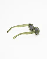 Lentes de sol negros con montura gruesa y forma ligeramente alargada y curvada, estilo 'cat eye' moderno. Los cristales son oscuros y polarizados.