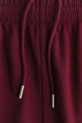 Pantalón deportivo de felpa color bordó, de corte recto y tiro mid-rise con cintura elástica.