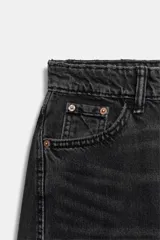 Jeans de tiro medio con corte cropped y diseño de costuras torcidas. Presenta trabillas en la cintura, cinco bolsillos clásicos y cierre frontal con cremallera y botón metálico.