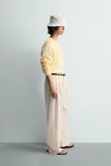 Jersey de punto color amarillo pálido, de corte relajado (relaxed fit), con cuello redondo y manga larga. Presenta acabados en rib en puños y bajo.