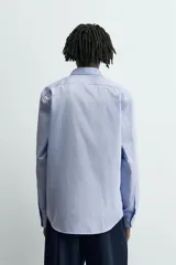 Camisa slim fit de algodón color celeste, con cuello italiano y manga larga con puños abotonados. Cierre frontal de botonadura.