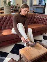 Zapato tipo zueco de cuero color chocolate con efecto desgastado, plataforma y taco cuadrado. Presenta una tira trasera ajustable con hebilla metálica.