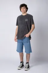 Remera de algodón color gris oscuro con efecto acid wash, corte semi-oversize y cuello redondo. Presenta un pequeño estampado circular en el pecho con un diseño de girasoles y texto.