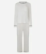 Pijama largo Lov de viscolycra color blanco con detalles de bies contrastante en negro. Está compuesto por una remera de manga larga con cuello redondo, bolsillo ojal en el pecho y pantalón de corte recto con cintura elástica.