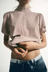 Camisa de manga corta con estampado de cuadros vichy, cuello subido y detalle de abertura en la espalda con lazada del mismo tejido.