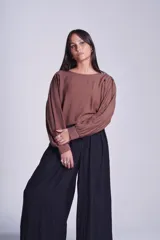Blusa negra de mangas largas abullonadas y cuello redondo.