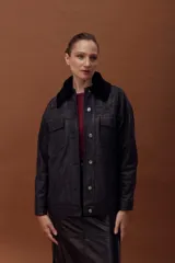Chaqueta de cuero ovino con efecto gastado, estilo jeanero, con cierre frontal de botones metálicos y bolsillos frontales. Posee mangas largas con puños y un cuello desmontable de corderito negro.
