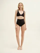 Culotte de bikini negro de inspiración retro, tiro alto y diseño con costuras laterales que estilizan la figura.