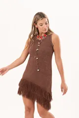 Vestido corto sin mangas de punto color marrón con sutil brillo, corte recto y dobladillo asimétrico adornado con flecos largos.