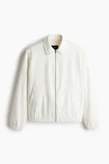 Campera de denim rígido color blanco, con cuello, cierre frontal, bolsillos insertados al bies y un bolsillo interior. Presenta elástico revestido en puños y bajo.