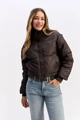 Campera puffer de corte cropped, color marrón oscuro, con cuello alto, cierre frontal con cremallera y botones a presión, y puños elásticos.