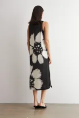 Vestido midi de satén sin mangas, color negro con gran estampado floral en blanco y negro.