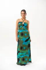 Vestido largo con estampado abstracto en tonos verdes, azules y negros. Presenta tirantes finos y cuello halter cruzado con detalle de abertura en el pecho.