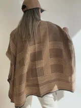 Ruana con diseño a rayas color gris y rosa, con borde de crochet negro.