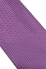 Corbata morada con pequeños lunares blancos.