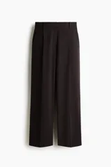 Pantalón amplio color negro, de corte holgado con pinzas, cierre con botón y corchetes ocultos, bolsillos laterales y piernas con pliegues adelante y atrás.