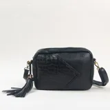 Bandolera negra de diseño rectangular con textura combinada, presentando un panel frontal con efecto reptil y el resto en acabado liso. Incluye una borla decorativa lateral y correa ajustable.