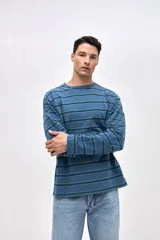 Remera de manga larga con diseño de rayas horizontales en tonos azules. Confeccionada en algodón lavado con textura suave y corte clásico.