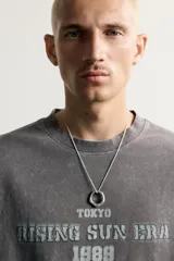 Remera de corte relaxed fit con efecto lavado, cuello redondo y manga corta, con estampado frontal contrastante.