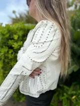 Chaqueta negra de cuero sintético con tachas plateadas, lentejuelas y strass.